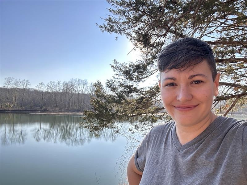 Kris smiling with a lake behind them